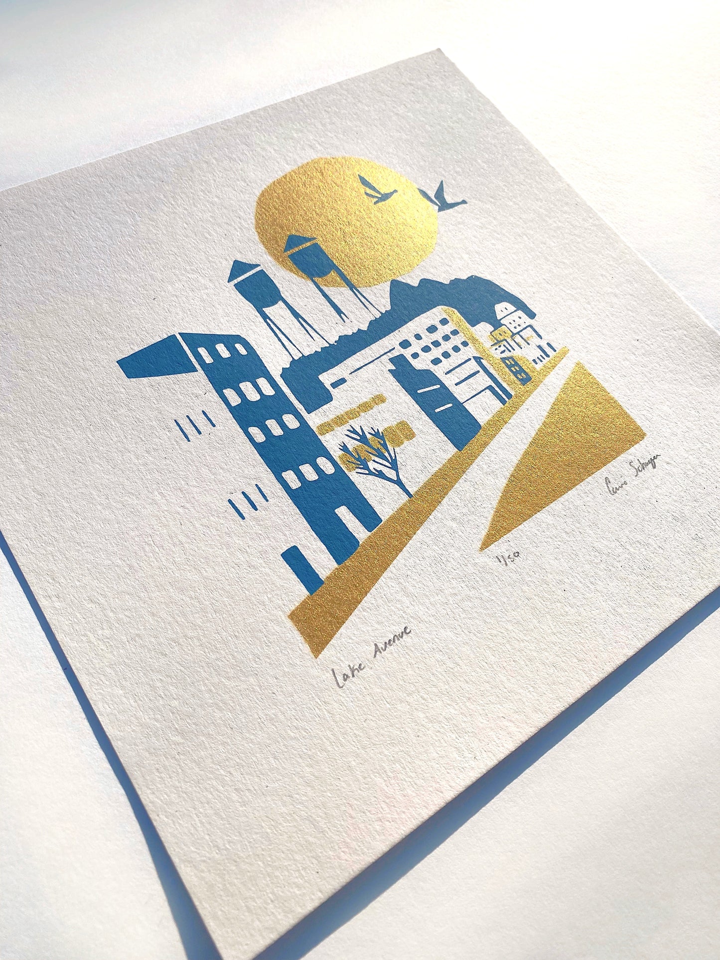 Modern minimal art print of Lake Avenue, Canal Park MN. Blue & gold ink. titled, numbered and signed. Flat lay view